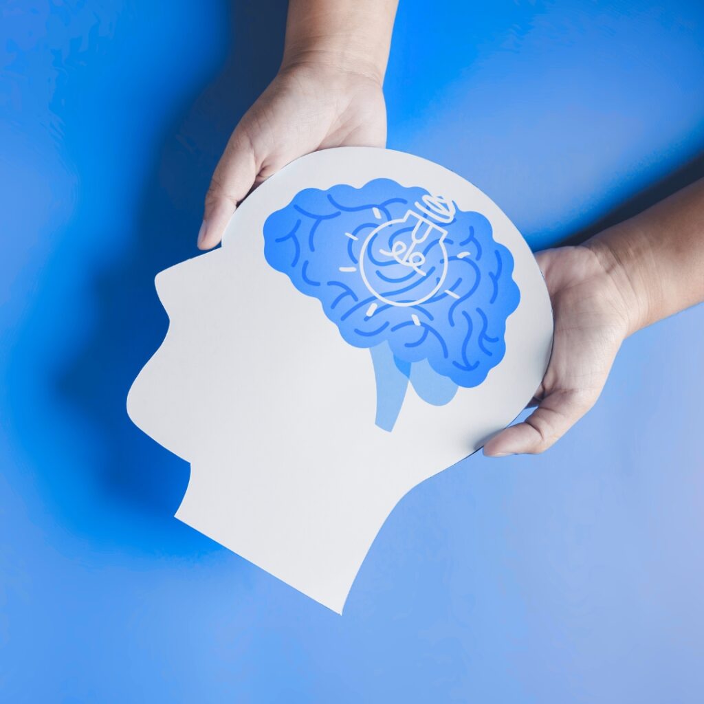 Paper cut-out of a head with a brain and a lightbulb