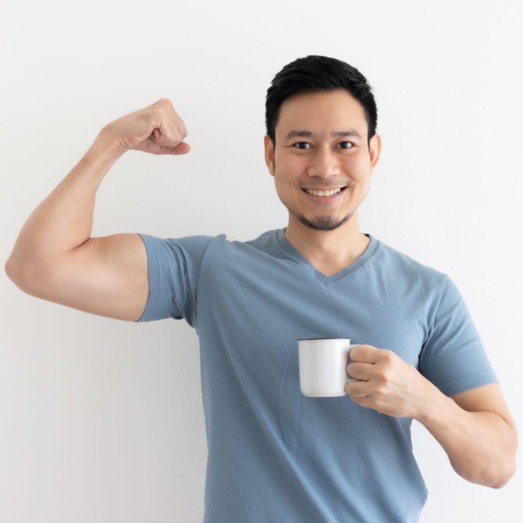 Man flexing bicep and holding a coffee cup