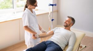 Man smiling while receiving an IV from a healthcare professional