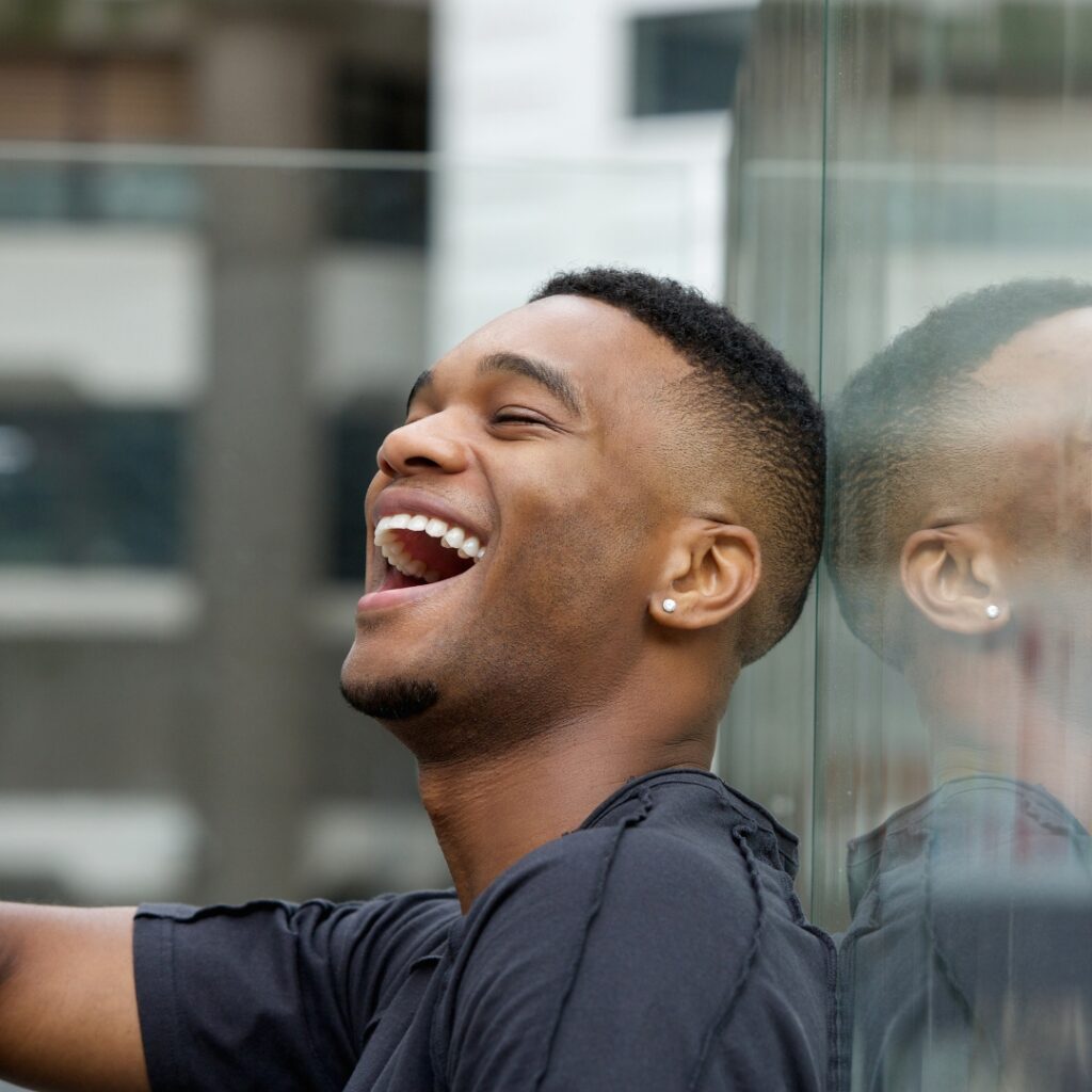 A man laughing heartily with his head tilted back.
