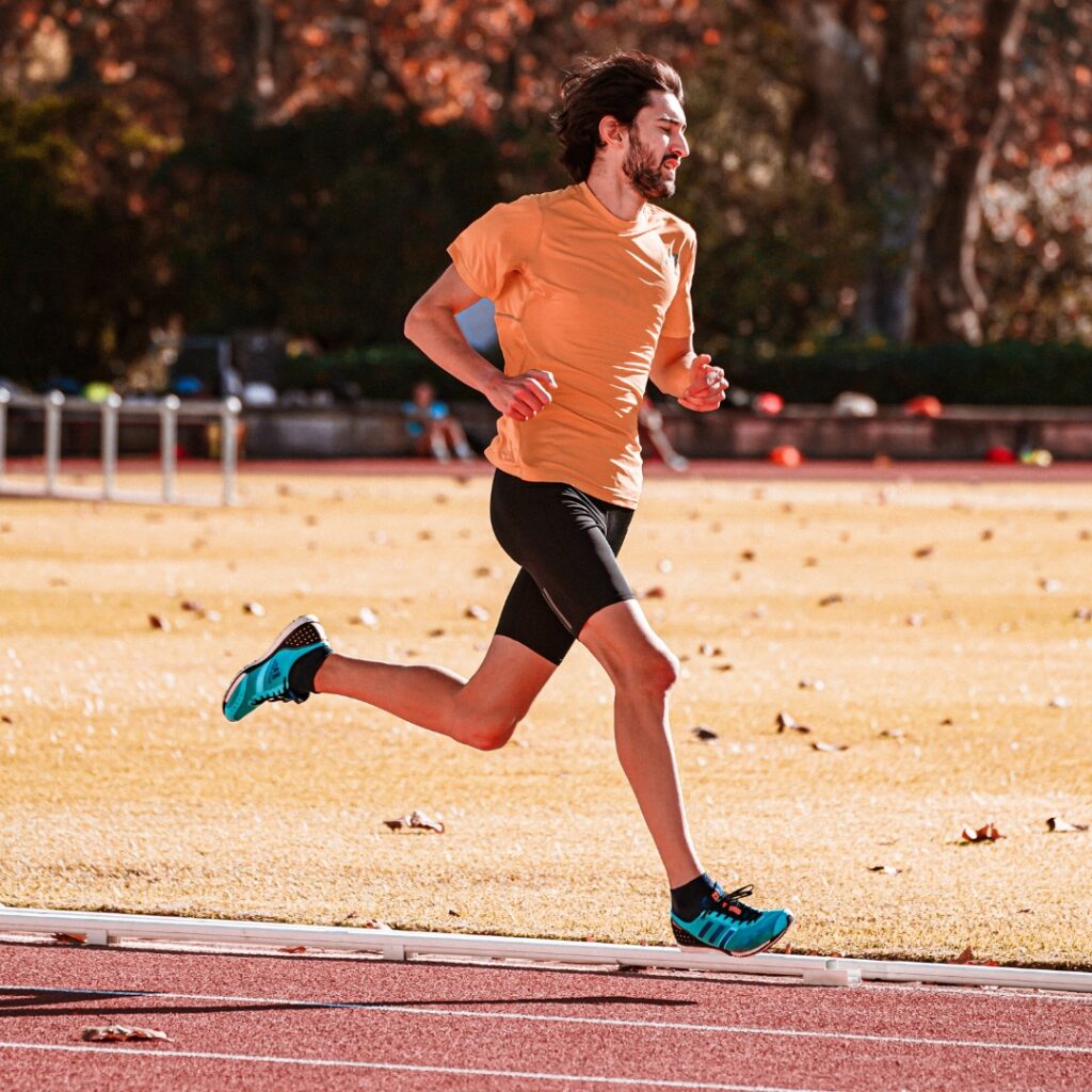 A man running on a track outdoors.